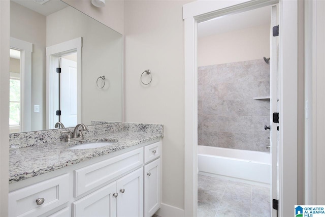 bathroom featuring vanity, tile patterned flooring, and tiled shower / bath combo