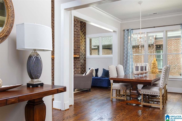 dining area featuring dark wood-type flooring and crown molding