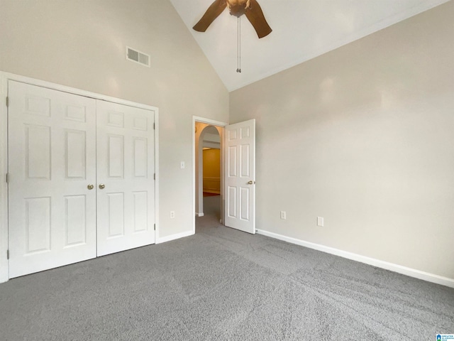 unfurnished bedroom with a closet, carpet, ceiling fan, and high vaulted ceiling