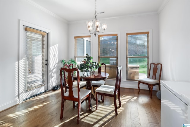 dining space with a notable chandelier, ornamental molding, and dark hardwood / wood-style floors