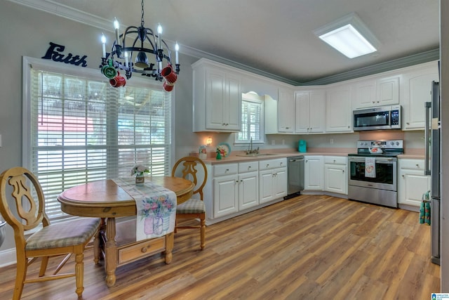 kitchen with white cabinetry, appliances with stainless steel finishes, crown molding, and sink