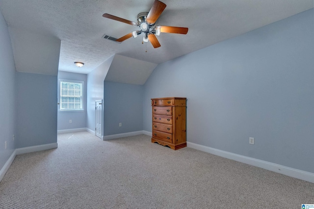 bonus room featuring ceiling fan, lofted ceiling, light carpet, and a textured ceiling