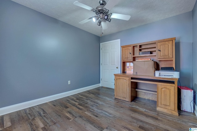 unfurnished office featuring ceiling fan, dark hardwood / wood-style floors, and a textured ceiling