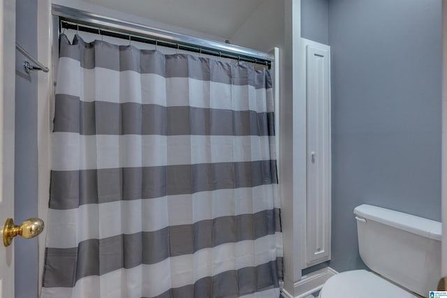 bathroom featuring toilet and a shower with shower curtain