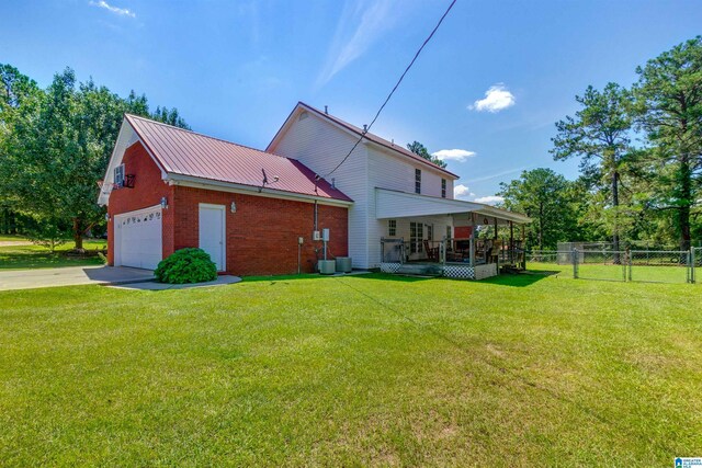 back of house with a porch, a garage, and a yard