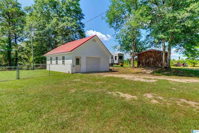 exterior space with a garage, an outbuilding, and a yard