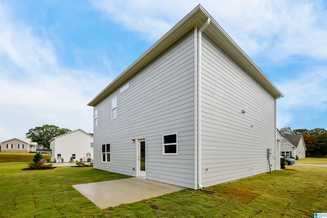 rear view of property featuring a patio and a lawn