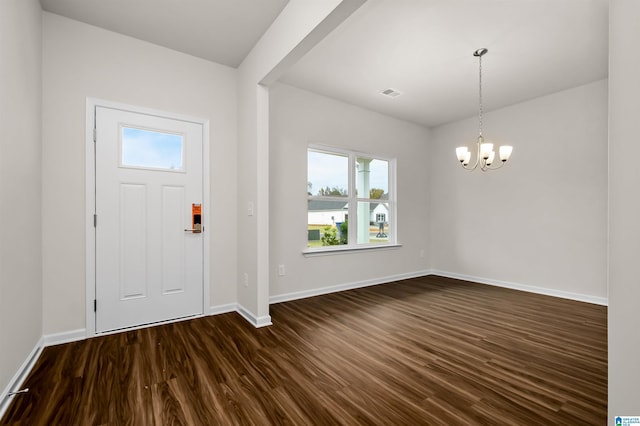 entrance foyer with dark hardwood / wood-style floors and a notable chandelier