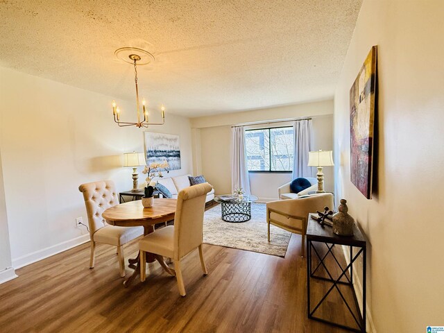 dining room with an inviting chandelier, a textured ceiling, and hardwood / wood-style flooring