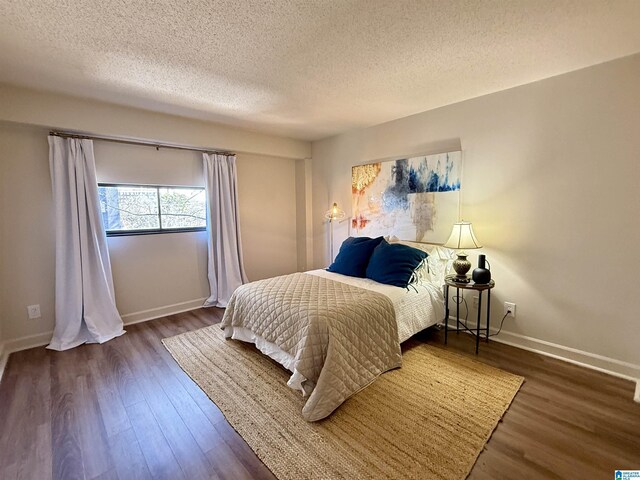 dining area featuring a textured ceiling, hardwood / wood-style floors, and an inviting chandelier