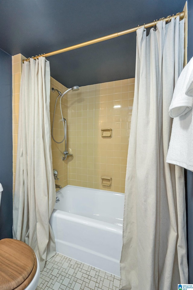 bathroom featuring toilet, tile patterned floors, and shower / tub combo