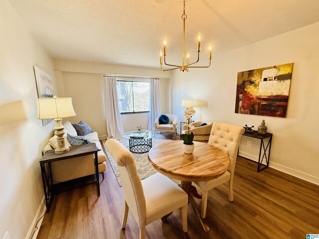 dining area featuring a textured ceiling, dark hardwood / wood-style flooring, and a notable chandelier