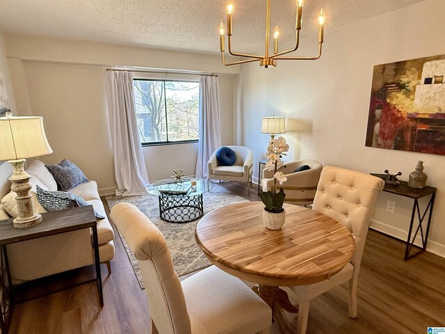 dining area featuring a notable chandelier, light hardwood / wood-style flooring, and a textured ceiling