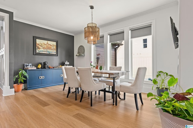 dining space featuring crown molding and light wood-type flooring