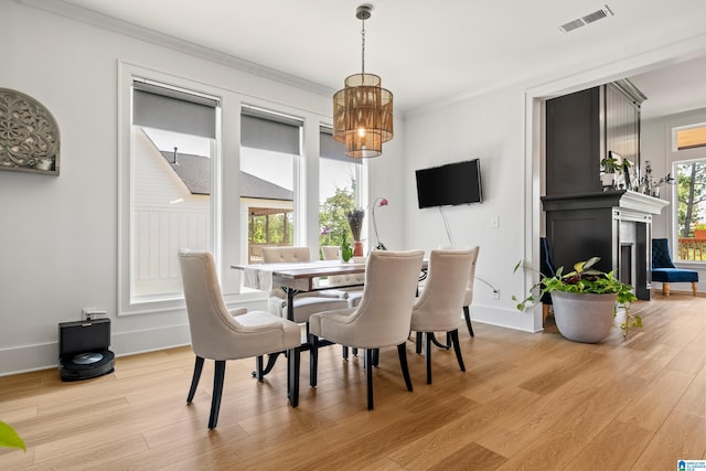 dining room with crown molding and light wood-type flooring