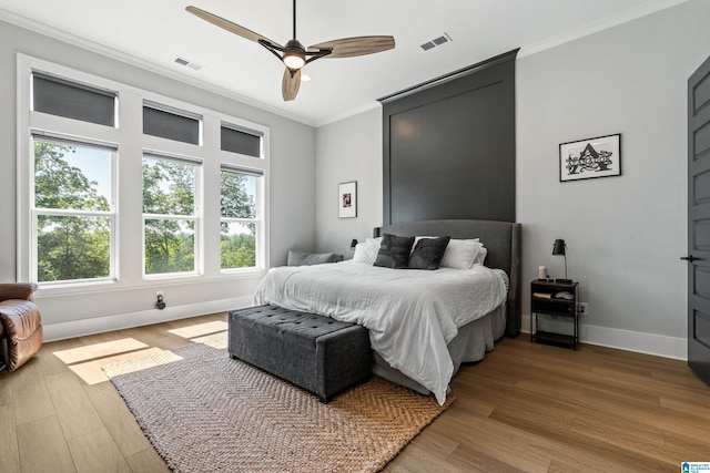 bedroom with crown molding, ceiling fan, and hardwood / wood-style floors