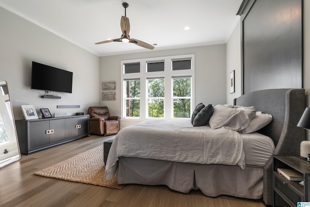 bedroom with crown molding, hardwood / wood-style floors, and ceiling fan