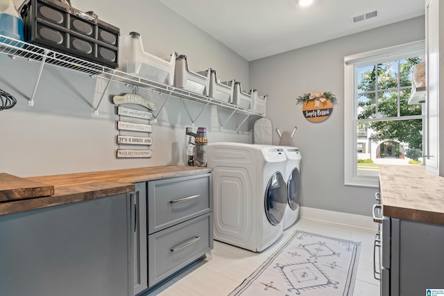 laundry area with cabinets, indoor bar, washer and dryer, and light tile patterned floors