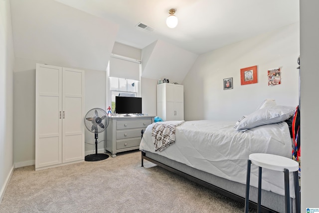 bedroom with lofted ceiling and light carpet