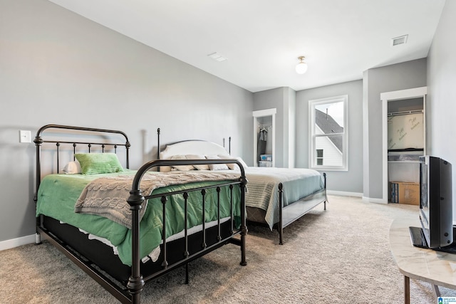 carpeted bedroom with a spacious closet and a closet