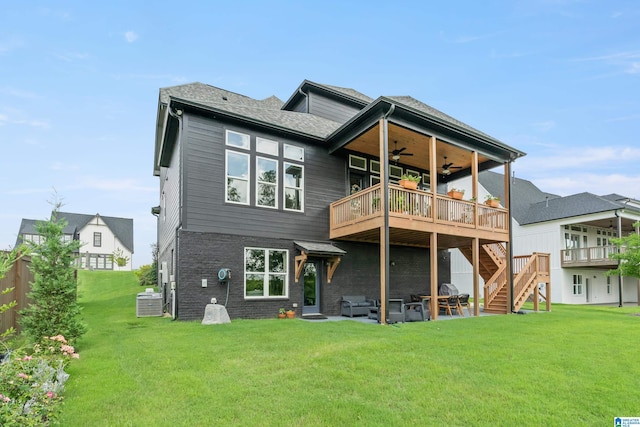 back of property featuring a wooden deck, ceiling fan, and a yard