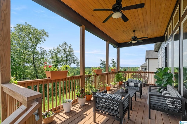 wooden terrace with an outdoor living space and ceiling fan