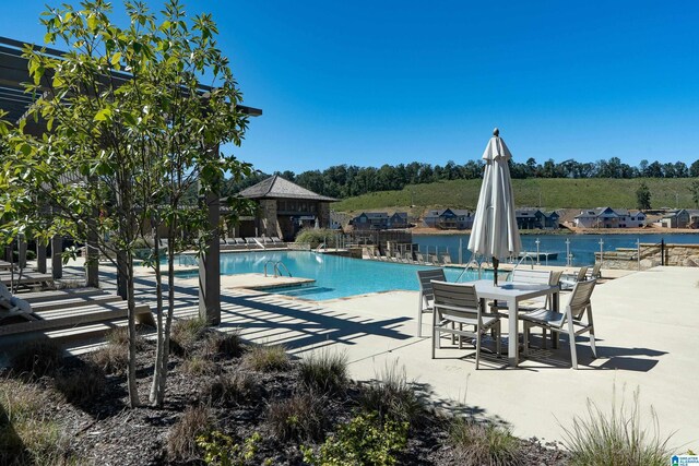 view of pool with a gazebo, a water view, and a patio area