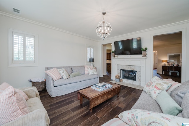 living room featuring a healthy amount of sunlight, a high end fireplace, an inviting chandelier, and ornamental molding