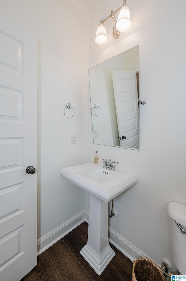 bathroom with toilet, sink, ornamental molding, and hardwood / wood-style flooring