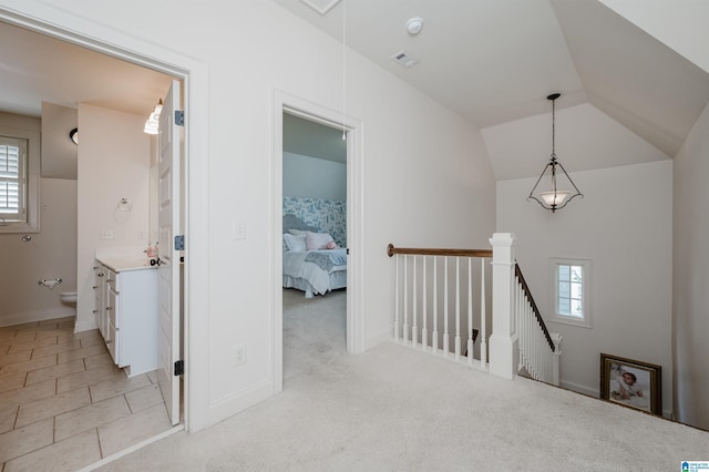 corridor featuring sink, a wealth of natural light, light carpet, and lofted ceiling