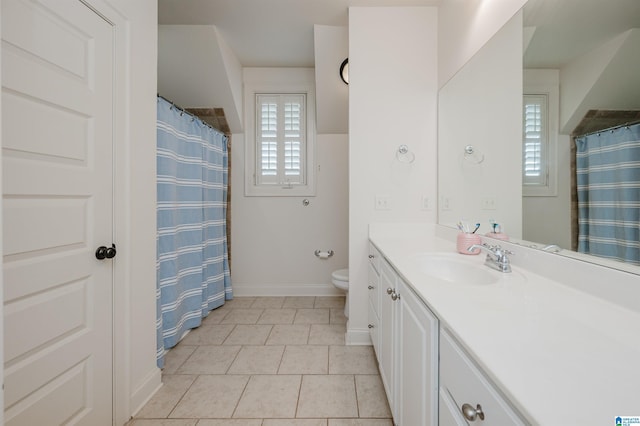 bathroom with toilet, tile patterned flooring, a healthy amount of sunlight, and vanity