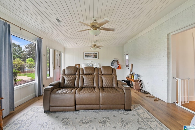 living room with ceiling fan, brick wall, wooden ceiling, and light wood-type flooring