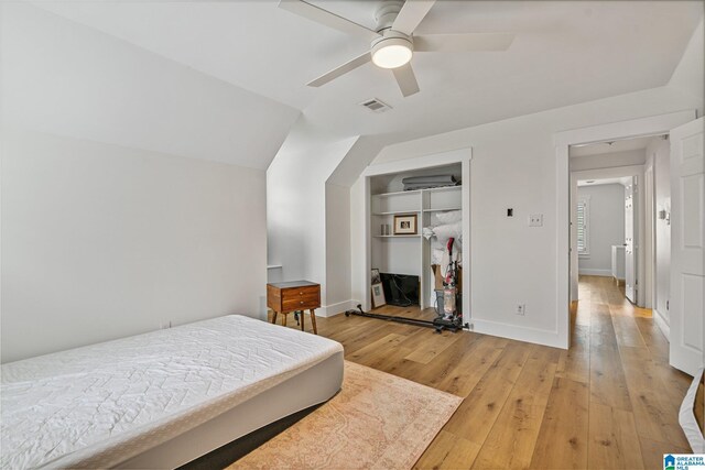 bedroom featuring vaulted ceiling, light hardwood / wood-style flooring, a closet, and ceiling fan