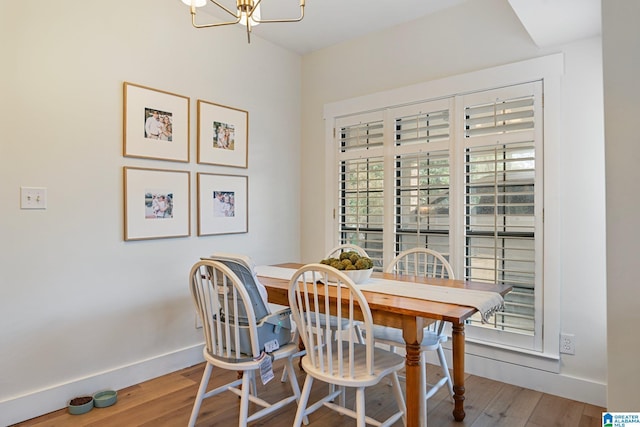 dining area featuring hardwood / wood-style floors and a notable chandelier