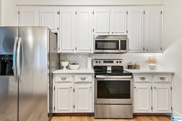 kitchen with decorative backsplash, light wood-type flooring, stainless steel appliances, and white cabinets