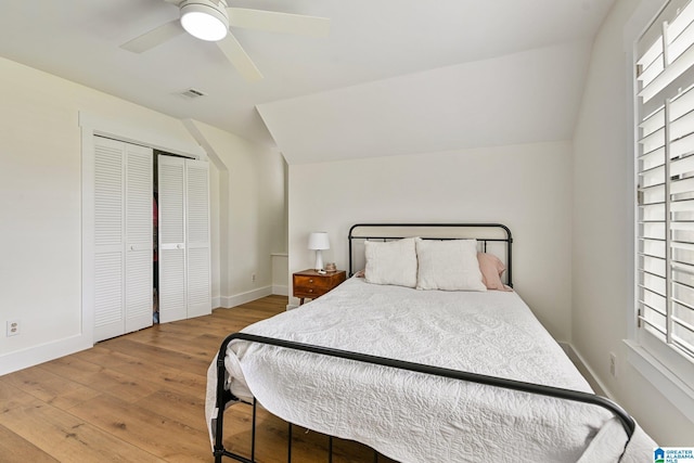 bedroom with multiple windows, vaulted ceiling, hardwood / wood-style floors, and ceiling fan