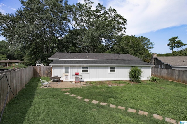 rear view of house featuring a yard and a patio