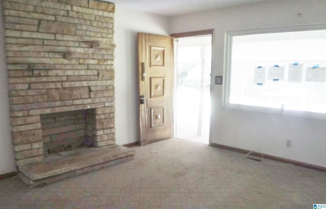 unfurnished living room featuring carpet floors and a fireplace