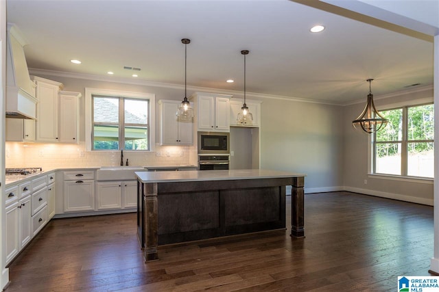 kitchen featuring built in microwave, oven, sink, and white cabinets