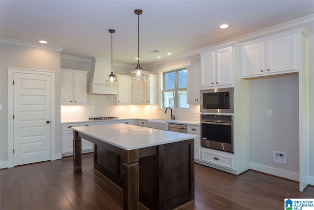 kitchen featuring pendant lighting, white cabinetry, a center island, stainless steel appliances, and custom range hood