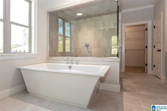 bathroom with ornamental molding, tile patterned flooring, and a tub