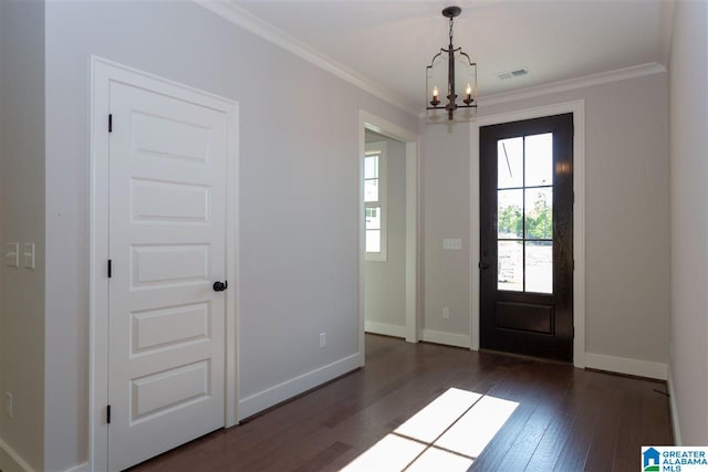 foyer entrance with crown molding, dark hardwood / wood-style flooring, and a notable chandelier