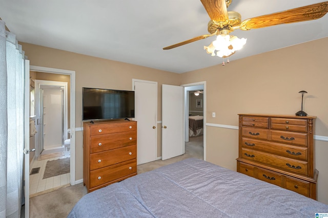 bedroom featuring light carpet, connected bathroom, and ceiling fan