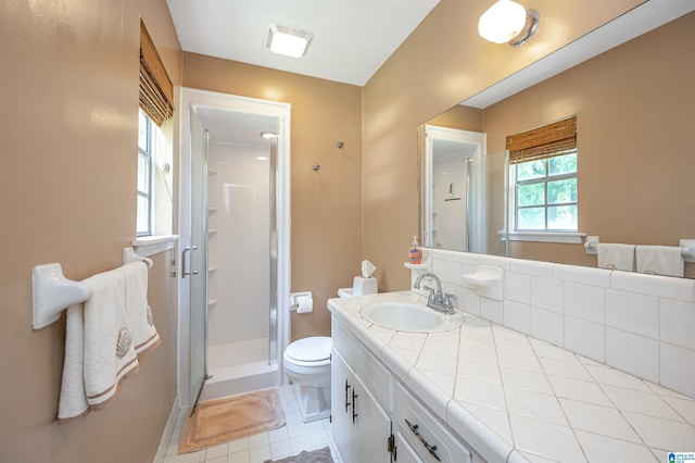 bathroom featuring tile patterned flooring, vanity, an enclosed shower, and toilet