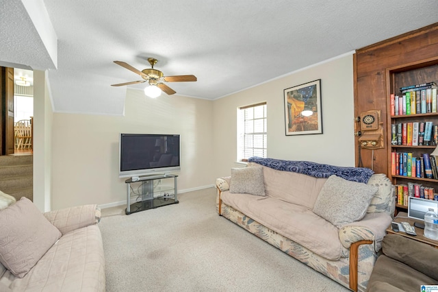 carpeted living room with ceiling fan, ornamental molding, and a textured ceiling