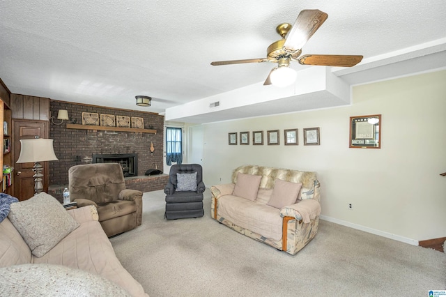 living room with ceiling fan, a fireplace, carpet floors, and a textured ceiling