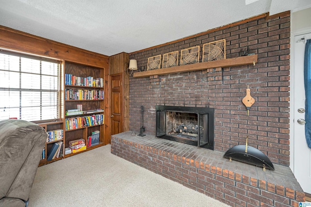 living room with a brick fireplace, carpet flooring, and a textured ceiling