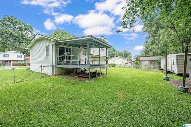 rear view of property with a yard, a deck, and a shed