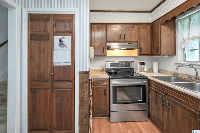 kitchen featuring crown molding, sink, electric range, and light hardwood / wood-style floors