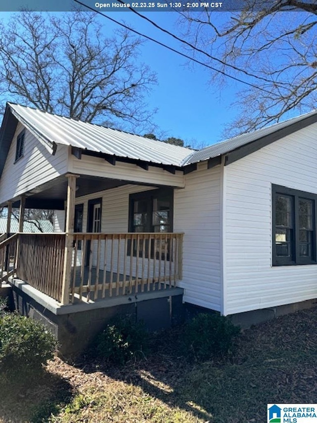 view of side of home featuring covered porch